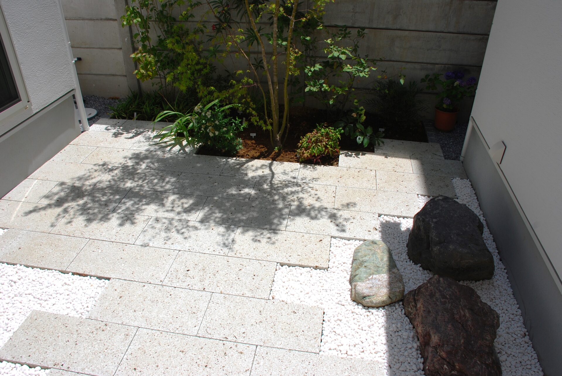 加須市の真白い壁と直線デザイン、植栽が美しい家を引き立てるシンプルを極めたオープン外構の和庭の大谷石