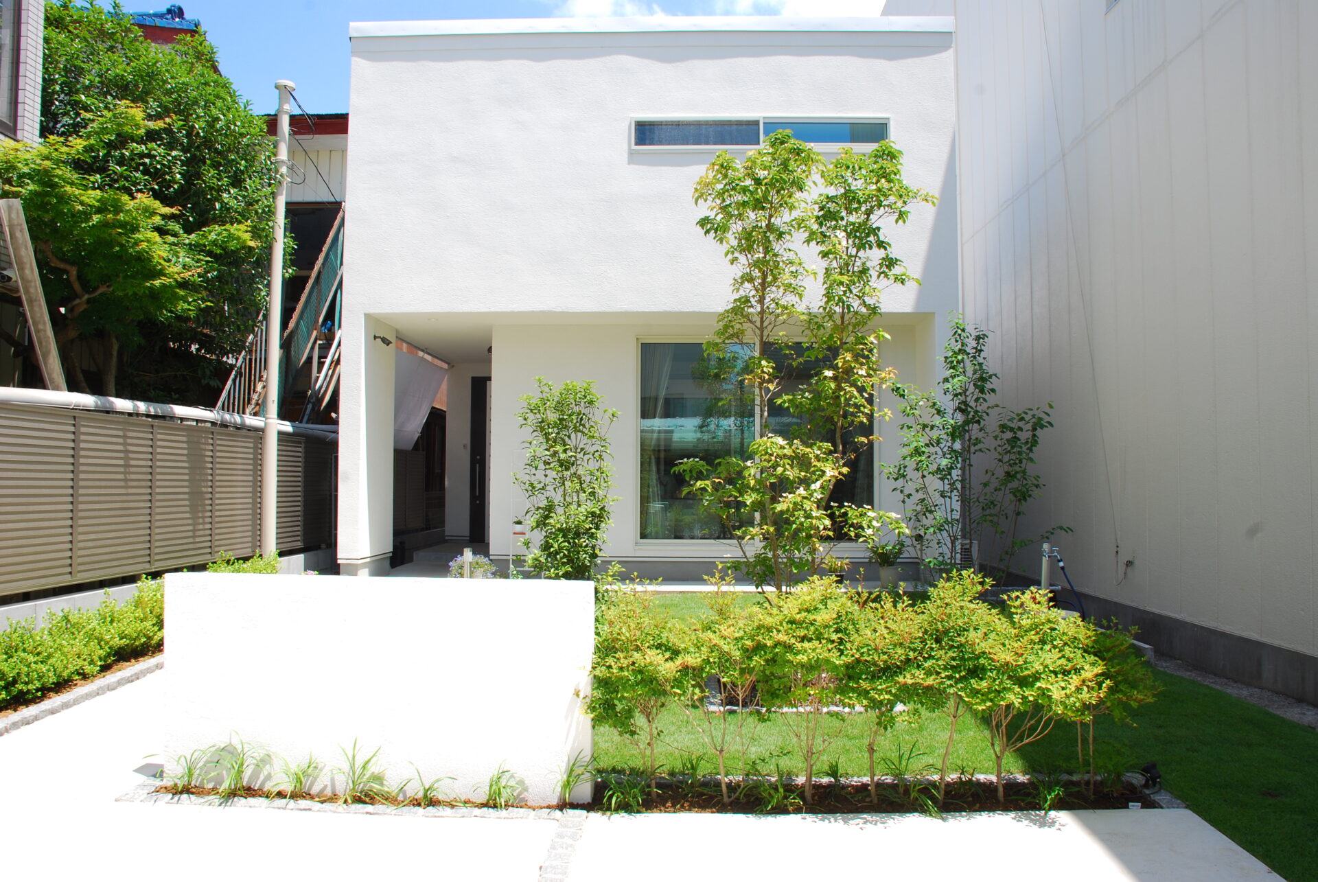 加須市の真白い壁と直線デザイン、植栽が美しい家を引き立てるシンプルを極めたオープン外構の正面