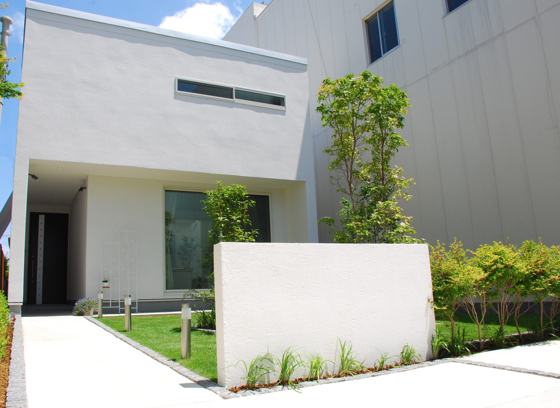加須市の真白い壁と直線デザイン、植栽が美しい家を引き立てるシンプルを極めたオープン外構