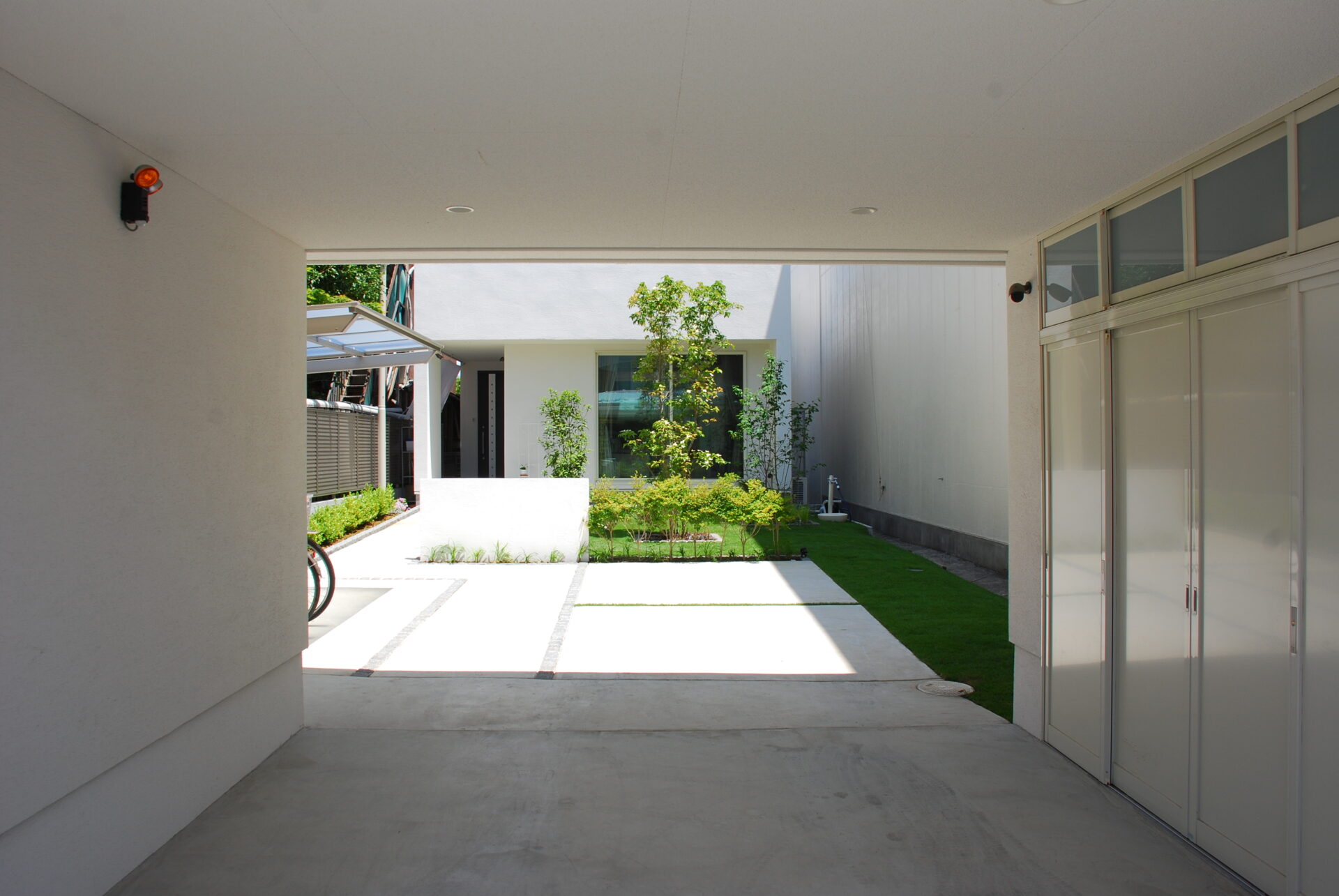 加須市の真白い壁と直線デザイン、植栽が美しい家を引き立てるシンプルを極めたオープン外構の入り口