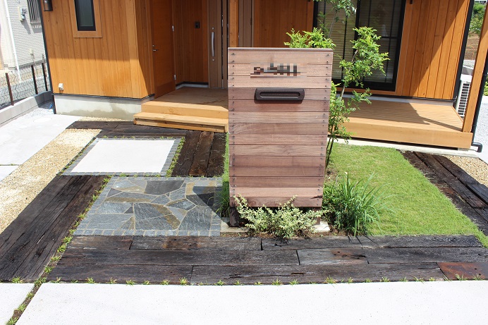 鴻巣市の天然木材のオリジナル門柱と多様な敷材使いと坪庭が特徴のエクステリアのアプローチ